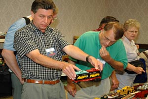 At a club-sponsored train show, a savvy shopper considers purchasing a Lionel Auto Loader car.